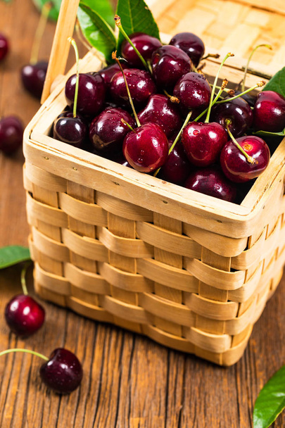 Cherries in a Wicker Basket Background. Selective focus. - Photo, Image
