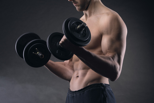 Exercising biceps with dumbbells - Foto, afbeelding