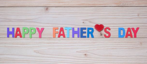 Joyeux texte de la fête des pères avec forme de coeur rouge sur fond en bois
 - Photo, image