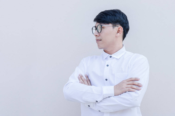 Ritratto laterale di ragazzo asiatico in camicia bianca su sfondo parete
. - Foto, immagini