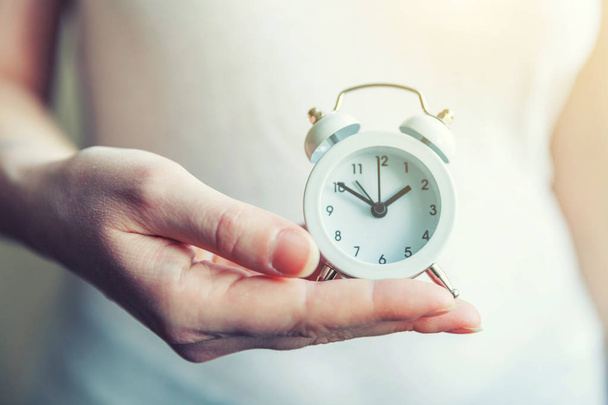 Mujer mujer manos sosteniendo timbre doble campana vintage reloj despertador clásico
 - Foto, Imagen