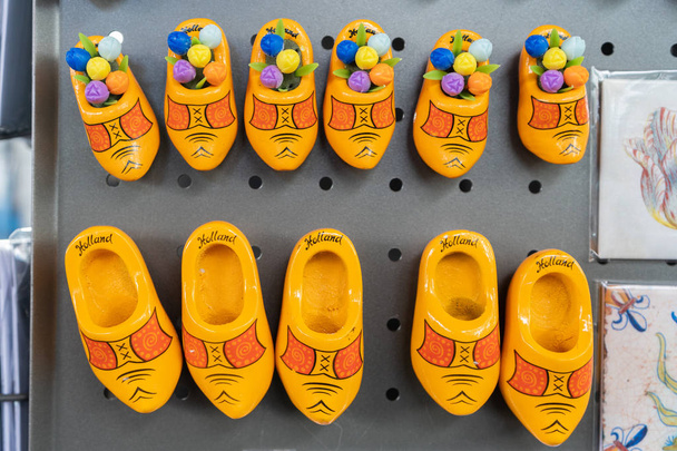 Gele Hollandse klompenmagneten als souvenirs uit Nederland, voor reizigers. Zegt Nederland en sommigen hebben houten tulpen. In een toeristenwinkel. - Foto, afbeelding