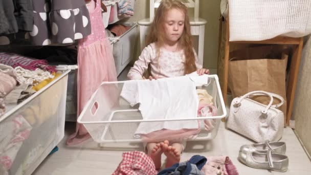 Mała dziewczynka czyści ubrania w domu szafa - Materiał filmowy, wideo