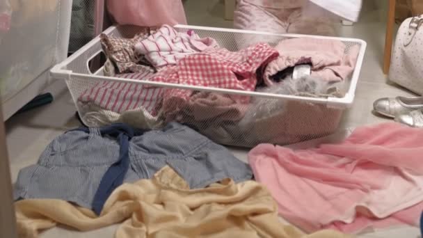Μικρό κορίτσι καθαρίζει ρούχα στο σπίτι ντουλάπα - Πλάνα, βίντεο