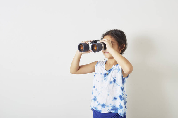Menina olhando para binocular
 - Foto, Imagem