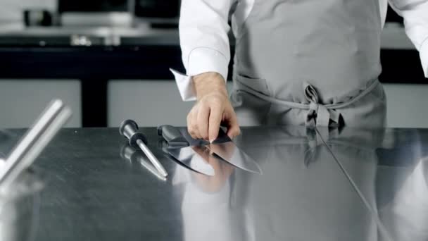 Chef se préparant à cuisiner à la cuisine. Gros plan mains de l'homme posant des couteaux
. - Séquence, vidéo