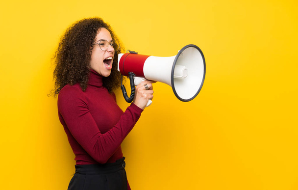 Dominican woman with turtleneck sweater shouting through a megaphone - Foto, Imagem