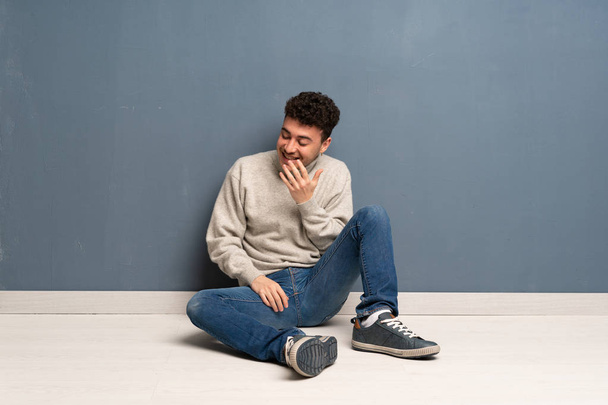 Mladý muž sedí na podlaze, hodně úsměvu - Fotografie, Obrázek