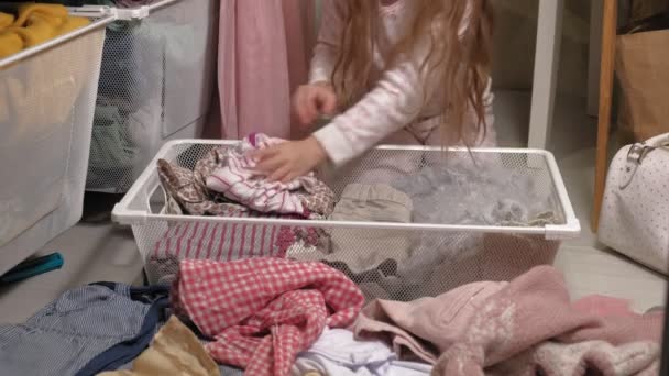 Kislány tisztítja a ruhákat otthon ruhásszekrény - Felvétel, videó