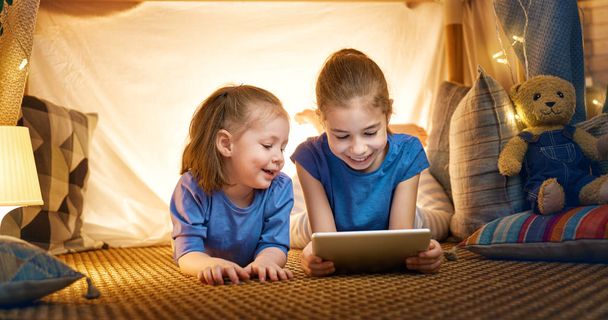 children are playing with tablet in tent - Foto, Bild