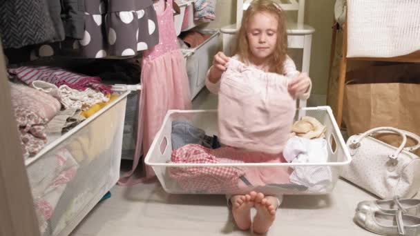 Pieni tyttö puhdistaa vaatteita kotona vaatekaappi
 - Materiaali, video