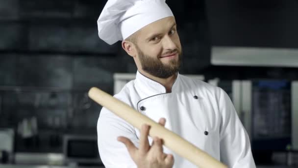 Chef człowiek gra z rolki w kuchni. Portret profesjonalnego szefa kuchni - Materiał filmowy, wideo