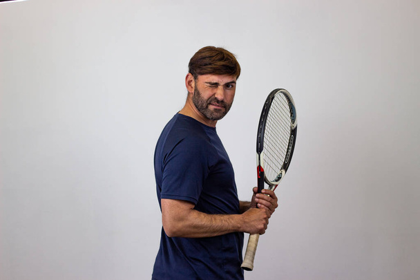 Portrait of handsome young man playing tennis holding a racket w - Photo, Image