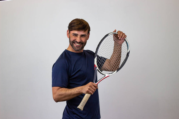 Portret przystojnego młodego człowieka grając w tenisa trzymając rakietę w - Zdjęcie, obraz