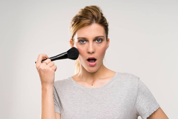 Young blonde woman with makeup brush - Foto, immagini