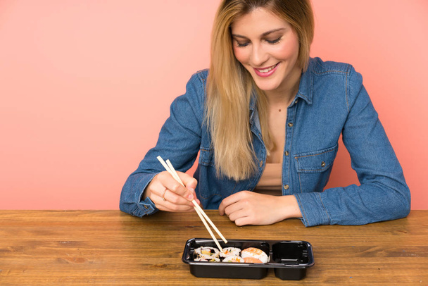 junge blonde Frau isst Sushi - Foto, Bild