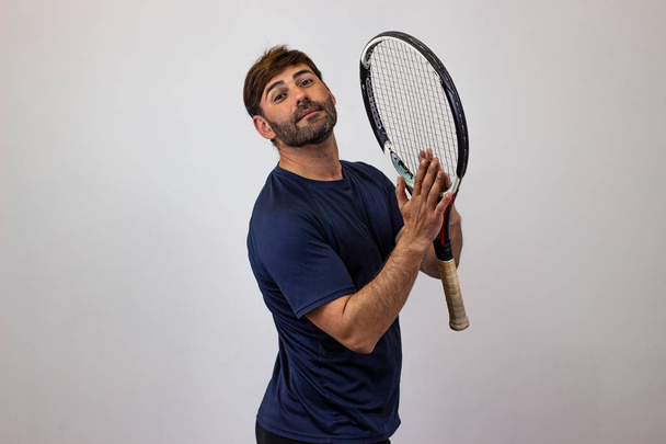 Portret przystojnego młodego człowieka grając w tenisa trzymając rakietę w - Zdjęcie, obraz