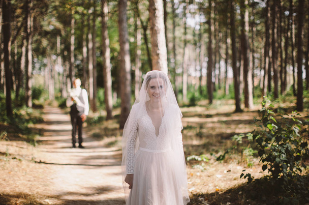stylish and tender couple in love - the bride and groom - on their wedding day on a walk in the woods, laughing and hugging - Фото, зображення