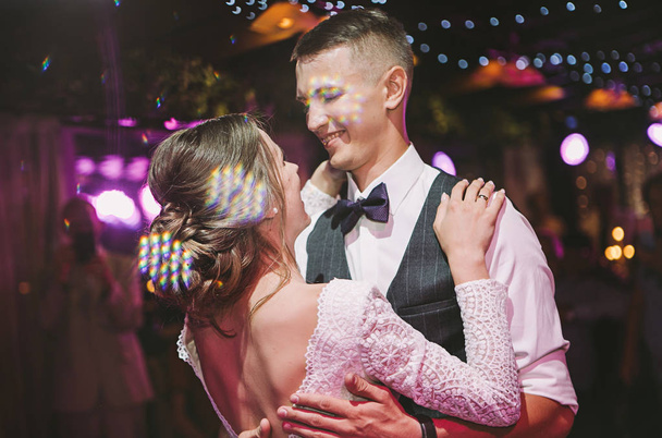 stijlvolle en tedere paar in liefde-de bruid en bruidegom-dansen op hun trouwdag, lachen en knuffelen - Foto, afbeelding