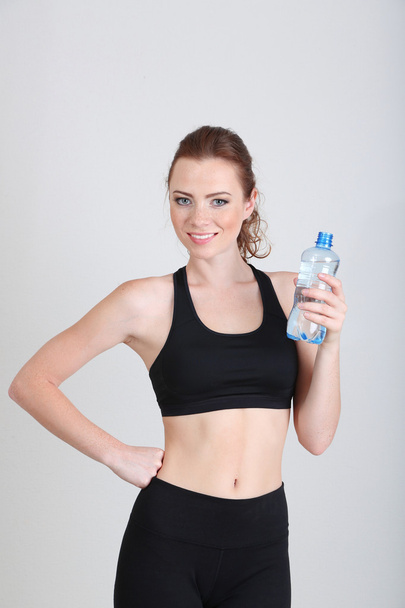 Beautiful young woman with bottle of water - Foto, afbeelding