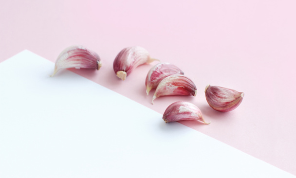 Fresh garlic on a light pink background - Фото, зображення