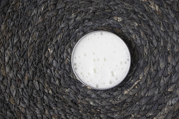 Φούσκα αφρού από σαπούνι, σαμπουάν ή καθαριστικό σε μεταλλικό δοχείο σε φυσικό φόντο - Φωτογραφία, εικόνα