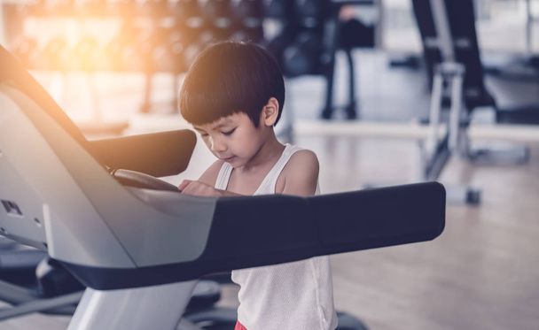 Asian dziecko działa na bieżni w siłowni fitness - Zdjęcie, obraz