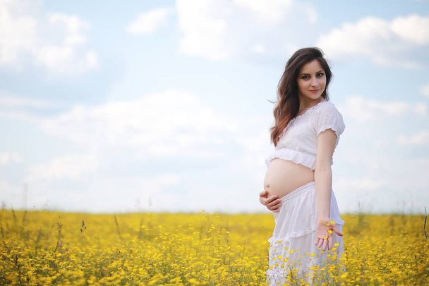 İçinde bir çiçek bir alanda hamile kadın - Fotoğraf, Görsel