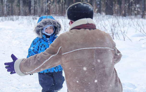 Kid playing in a winter park and have fun with family - Photo, Image