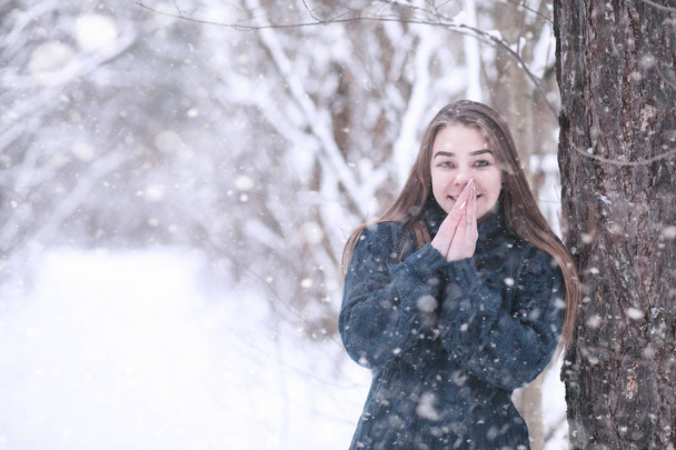 Lány a téli parkban hóesésben - Fotó, kép