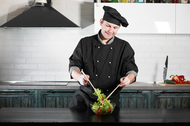 Чоловік готує їжу за кухонним столом з овочів
 - Фото, зображення