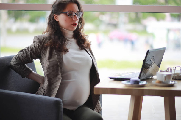 妊娠中の女性がカフェ内のコンピューターでの作業 - 写真・画像