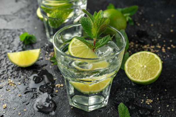 Mojito cocktail with Rum, lime and mint in glass. Summer cold drink with ice - Фото, зображення