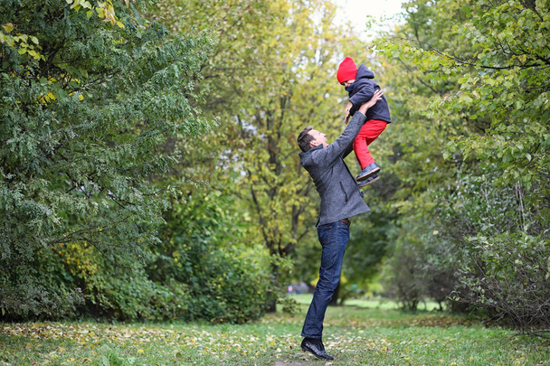 Wiosną młody ojciec z synem na spacerze po parku - Zdjęcie, obraz