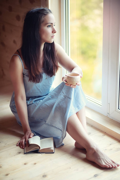 A girl at the window in the house - 写真・画像