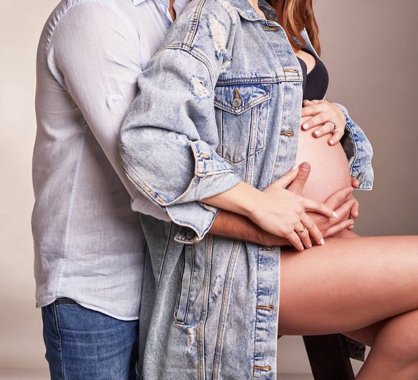 zwanger paar in een frame zonder gezicht - Foto, afbeelding