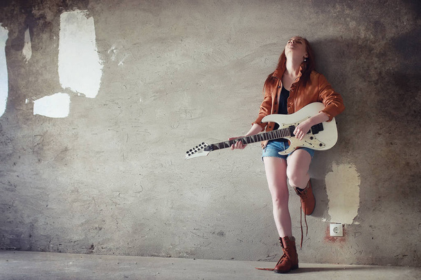 Jeune fille rousse avec une guitare électrique. Rock musicien gir
 - Photo, image