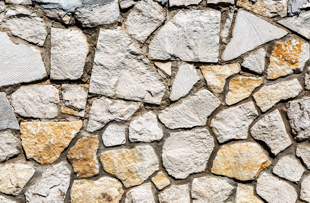Verweerd grijze stenen muur als creatieve achtergrondstructuur - Foto, afbeelding