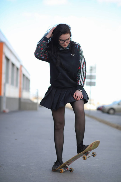 Молода дівчина-хіпстер їде на скейтборді. Дівчата подружки f
 - Фото, зображення