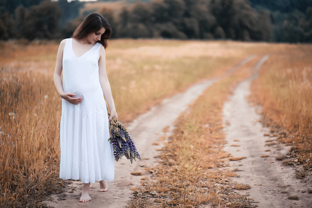 Doğada hamile bir kadın sonbaharda yürüyüşe çıkıyor. - Fotoğraf, Görsel