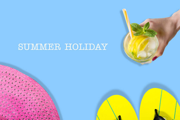 The concept of a summer holiday. Beach slippers, hat and summer cocktail on a blue background. Copy space. View from above. Place for text. Easy to clean text. Summer holiday banner. - Foto, Imagen