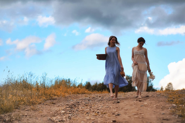 Dwie piękne dziewczyny w sukienkach jesienią polu z Berrie - Zdjęcie, obraz