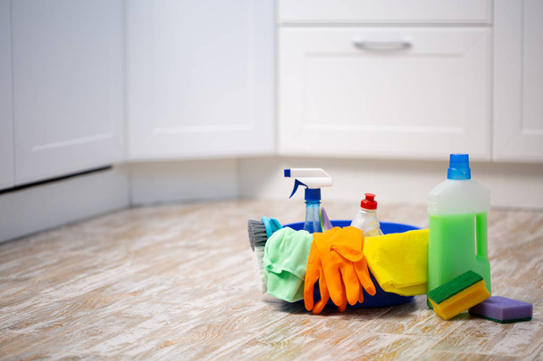 Set of cleaning supplies on floor in kitchen. Space for text - Foto, Bild