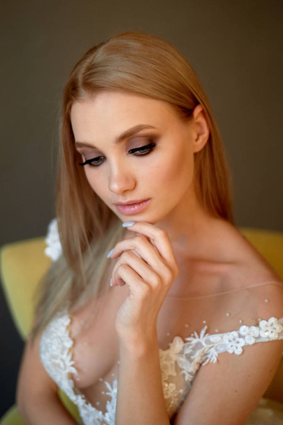 Portrait of a beautiful bride in a lace dress.Makeup smoky eyes, emphasis on eyes. Long flowing hair. - Foto, Imagem