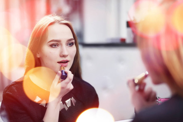 Młoda dziewczyna robi makijaż w salonie kosmetycznym. Dziewczyna w przód o - Zdjęcie, obraz