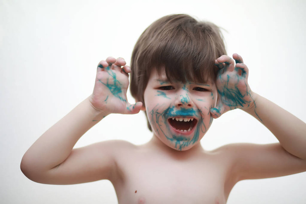 Un niño pintó su cara con colores
 - Foto, imagen