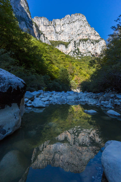 mountain reflected in river of Vikos gorge in greece in autumn - Foto, imagen