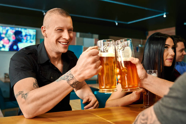 Happy man toasting with beer with friend in pub - Φωτογραφία, εικόνα