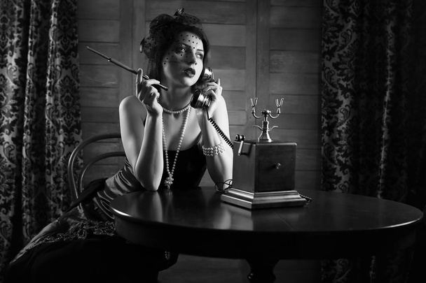 Linda garota dos anos 1930 fuma monocromático
 - Foto, Imagem