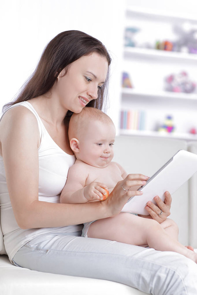 mom and baby are looking at the digital tablet screen - Zdjęcie, obraz